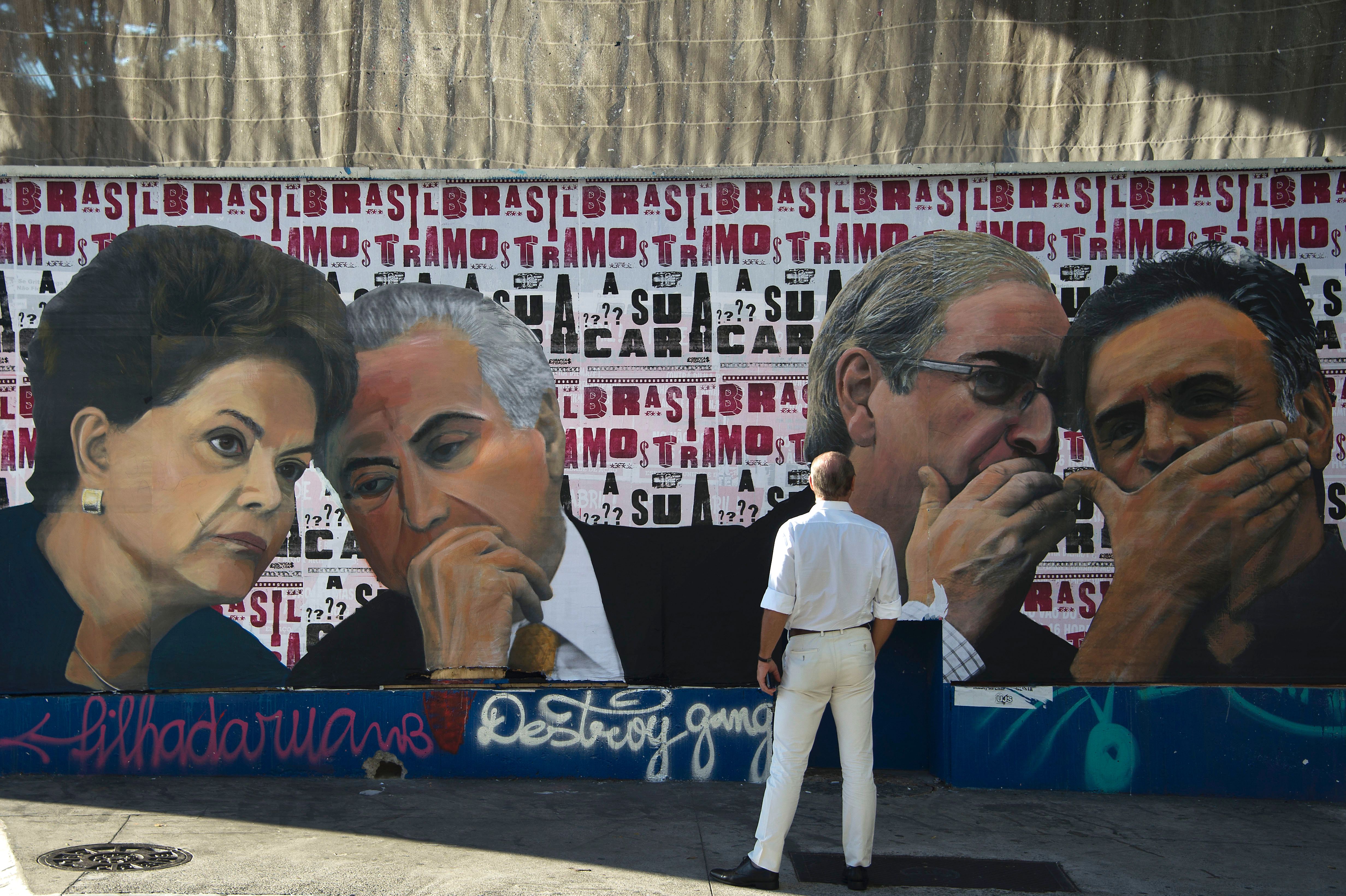 Un hombre mira a un mural en Sao Paulo en el que se ve (de izquierda a d...