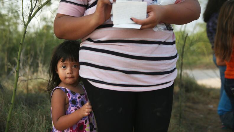 Una niña migrante indocumentada junto a su madre en un punto de la front...