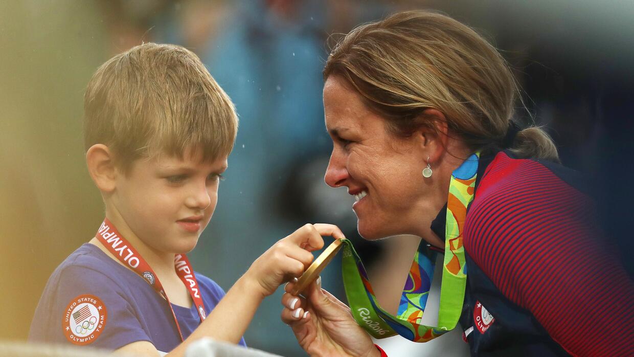 Kristin Armstrong enseñando la medalla a su hijo Lucas