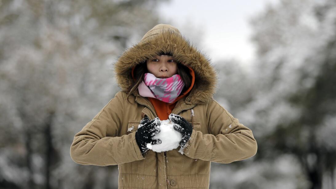 Christine Co makes a snowball while playing in the snow Friday, Dec. 8,...