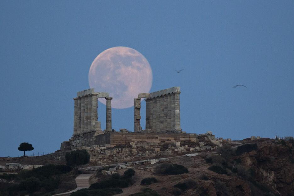La "luna de fresa" se recorta sobre las ruinas del templo de Poseidón, e...