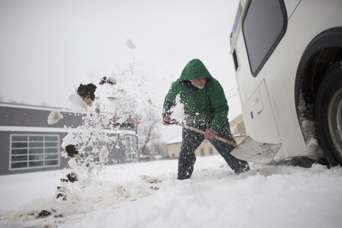 Blaine Webb, de 52 años, saca la nieve de un autobús en Spring City, Pen...
