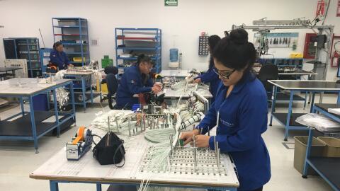 Trabajadores mexicanos realizan labores en una compañía de ensamblaje